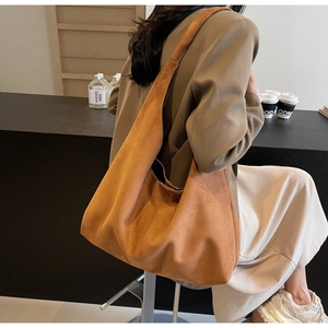 Détail d'un grand sac cabas en daim marron caramel avec un design spacieux élégant