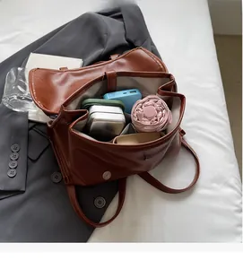 Top view of spacious interior storage in a brown faux leather backpack with daily essentials