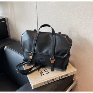 Detail of black leather backpack with FREE 1981 COLOR embossed text and gold buckle