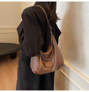 Detail of dark brown lychee textured hobo bag with stylish chain and leather strap