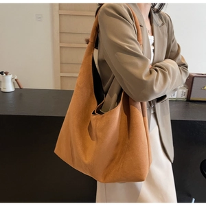 Side view of a large brown suede tote bag showing its spacious capacity and soft texture