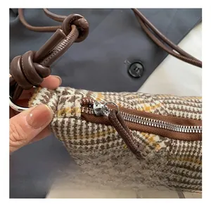 Dettaglio della borsa a mezzaluna in tweed con finiture argento e tracolla a nodo