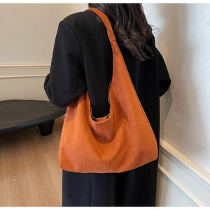 Detailed view of the caramel suede tote bag textured surface and wide shoulder strap