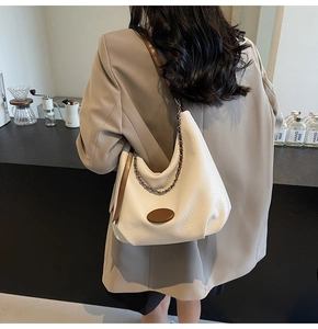 Detail view of cream dumpling shoulder bag with chain strap and vintage textured leather