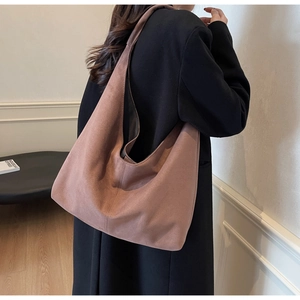 Minimalist large pink suede tote bag shown on shoulder in a retro French interior
