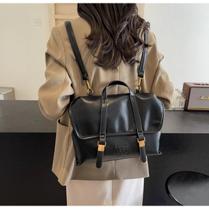 Detail of black leather backpack with FREE 1981 COLOR embossing and gold metal buckles