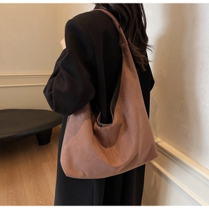 Sac hobo marron en daim porté à l'épaule pour un style minimaliste et élégant quotidien