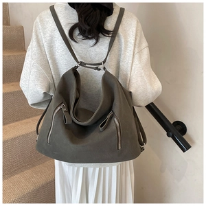Détail d'un sac à dos rétro gris avec texture mate et poches zippées latérales en métal