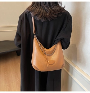 Detail of caramel lychee leather hobo bag with silver chain and adjustable shoulder strap