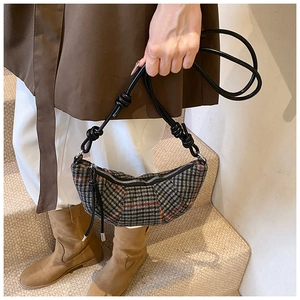 Dettaglio borsa a mezzaluna a quadri vintage con trama della tracolla in pelle annodata