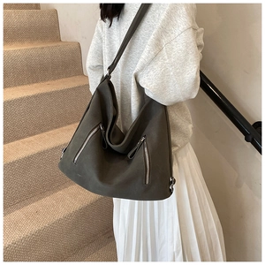 Détail d'un sac cabas vintage gris foncé avec fermetures éclair argentées et cuir mat