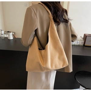 Detail of soft suede tote bag with reinforced side stitching in a retro cafe setting