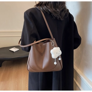 Close-up of brown lychee grain leather tote bag featuring a cute white cloud charm