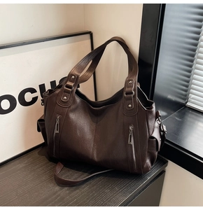 Macro detail of dark brown faux leather tote with decorative zippers and side pocket
