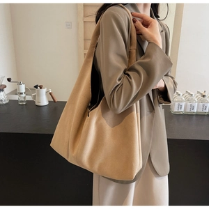 Close-up of large khaki suede tote bag with shoulder strap shown on a model
