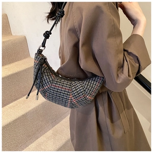 Dettaglio di una borsa a mezzaluna a quadri grigi in tweed con tracolla in pelle nera
