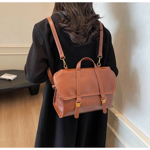 Detailed back view of a vintage brown leather backpack with adjustable shoulder straps