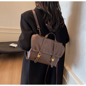 Detail of vintage brown leather bag with buckle straps and debossed text on smooth texture