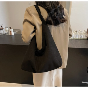 Détail du grand sac hobo en daim noir montrant la texture et le drapé naturel chic