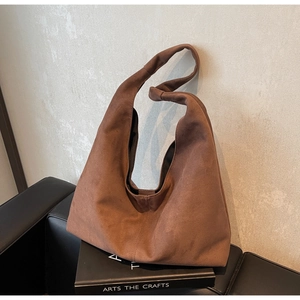 Gros plan d'un cabas en daim marron avec détail de poignée nouée décorative