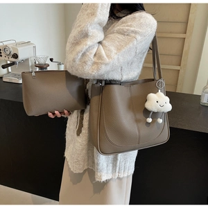 Detail of dark khaki lychee texture bucket bag with a cute white cloud plush pendant