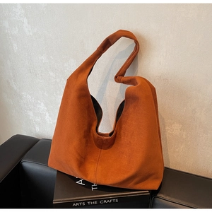 Détail d'un sac hobo en daim caramel doté d'une bandoulière à nœud unique
