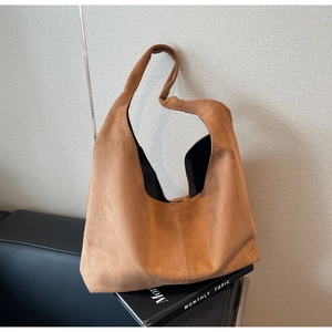 Détail d'un sac Hobo en daim marron avec un design de bandoulière nouée décorative