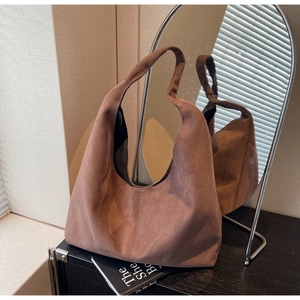Close-up of brown suede hobo tote bag with a minimalist design and soft slouchy texture