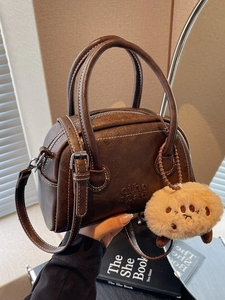 Retro dunkelbraune Bowling-Tasche aus Leder mit Kontrastnähten und Plüsch-Anhänger