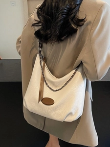 Chic white leather hobo bag with textured grain and chain strap shown on model shoulder