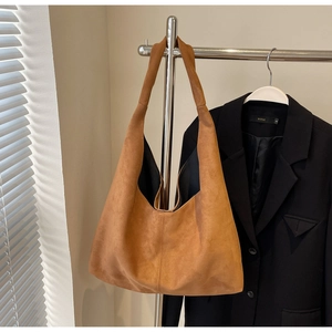 Vue détaillée du grand sac hobo en daim marron montrant la texture douce du cuir