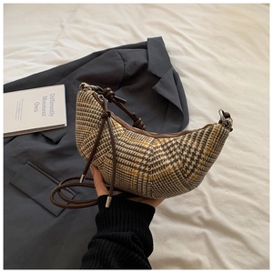 Dettaglio della borsa a mezzaluna in tweed a quadri marroni con tracolla in pelle