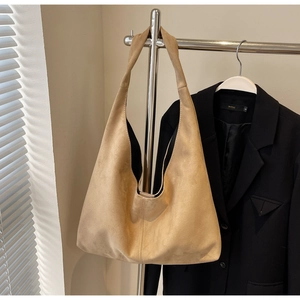 Détail d'un grand sac fourre-tout en daim mat fauve avec couture verticale sur support