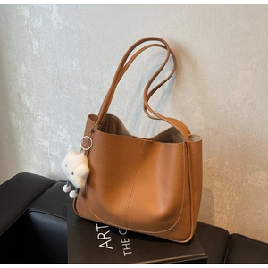 Brown litchi texture tote bag with plush cloud charm on a minimalist display