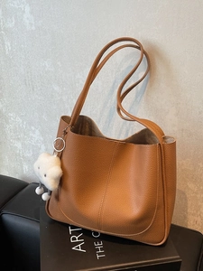 Brown lychee leather tote bag with shoulder straps and a white cloud plush charm