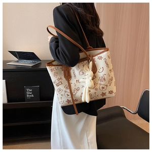 Dettaglio della grande borsa tote graffiti con stampe vintage e ciondolo a forma di coniglio