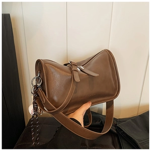 Detail view of a vintage dark brown leather shoulder bag with a unique geometric shape and strap