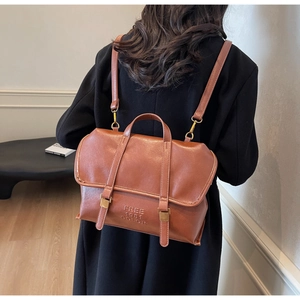 Vista posteriore di una modella con zaino vintage in ecopelle marrone e fibbie in metallo