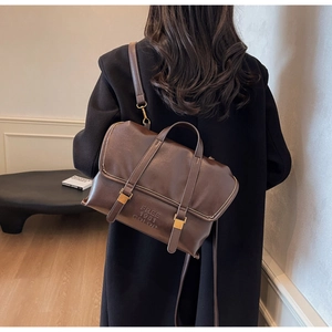 Dettaglio zaino in pelle marrone con fibbie dorate e logo Free 1981 Color in rilievo