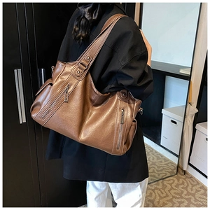 Detail einer großen dunkelbraunen Kunstleder-Tote-Tasche mit stylischen Metallreißverschlüssen