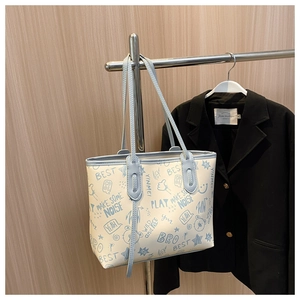 Detailaufnahme weißer Shopper mit blauen Graffiti-Mustern und hellblauen Trageriemen