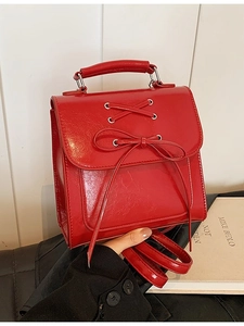 Red leather academic style backpack with lace-up bow detail and top handle for women