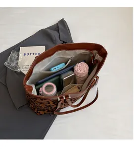Intérieur spacieux du sac cabas léopard montrant le rangement pour tablette et parapluie