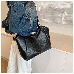 Dettaglio della grande borsa tote nera con logo HNKBAG in rilievo e trama in ecopelle grinzosa