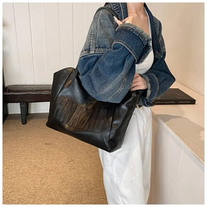 Dettaglio di una borsa tote nera con logo HNK BAG a rilievo e trama in pelle pregiata