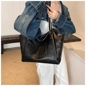 Dettaglio della borsa tote in pelle nera con logo HINKBAG goffrato sulla spalla