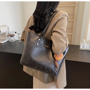 Detailansicht der großen matten Leder-Tote-Bag mit SHYTHMAN-Logo und Plüsch-Anhänger