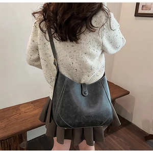Detail of grey matte shoulder bag with white contrast stitching and PANTOUR embossed logo