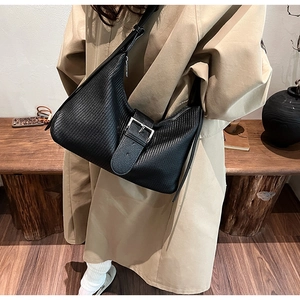 Close-up of black woven texture hobo bag with a stylish silver square metal buckle