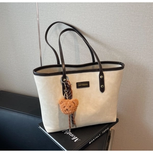 Große beige Tragetasche mit braunen Trägern und süßem Teddybär-Anhänger Detail